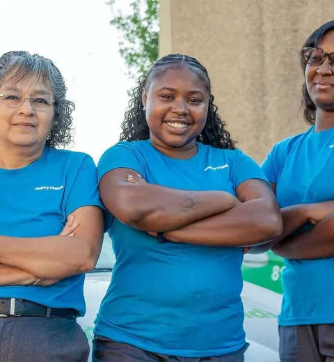 merry maids posing beside a merry maids branded vehicle